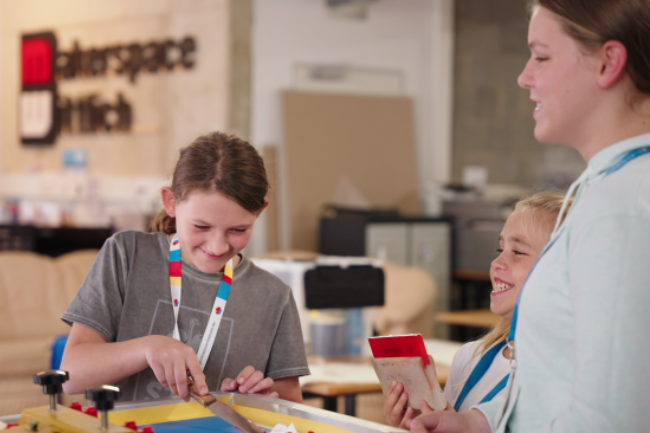 Zwei Mädchen und eine junge Frau in einem Makerspace