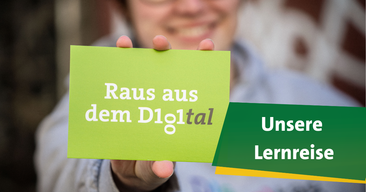 Lächelnde Frau hält Postkarte mit der Aufschrift 