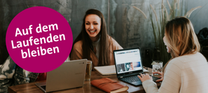 Drei Frauen sitzen an einem Tisch und arbeiten zusammen vor Laptops. Runder magentafarbener Kreis mit der Aufschrift: Auf dem Laufenden bleiben.